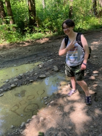 Me posing next to puddle algae that says 'poop'